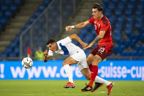 Greece's Marios Vrousai, left, fights for the ball against Switzerland's Cedric Zesiger, right, during a soccer test match between Switzerland and Greece at the St. Jakob-Park stadium in Basel, Switze ...