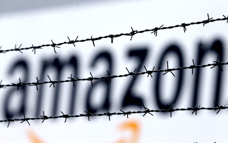 FILE - In this Feb. 19, 2013 file photo, the internet trader Amazon logo is seen behind barbed wire at the company&#039;s logistic center in Rheinberg, Germany. A European Union court annulled Wednesd ...