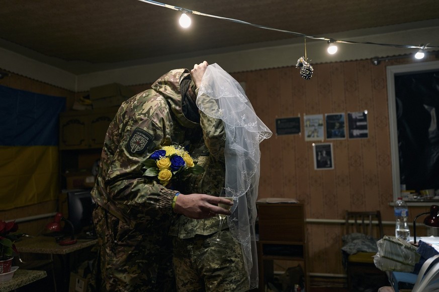 Ukrainian army medics Eugenia and Oleksander kiss during their wedding ceremony in Lyman, Donetsk region, Ukraine, Saturday, Dec. 24, 2022. (AP Photo/Felipe Dana)