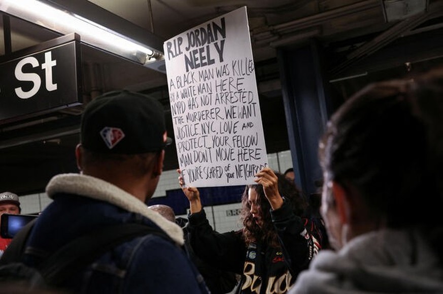A woman holds a sign during a protest at the Broadway-Lafayette subway station, after according to local media reports a 30-year-old man acting erratically on a F subway train died on Monday afternoon ...
