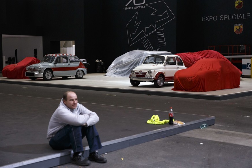 Un technicien fait une pause sur le stand d'exposition d'Abarth Special, lors des derniers préparatifs du 89<sup>e </sup>Salon international de l'automobile de Genève, en mars 2019.