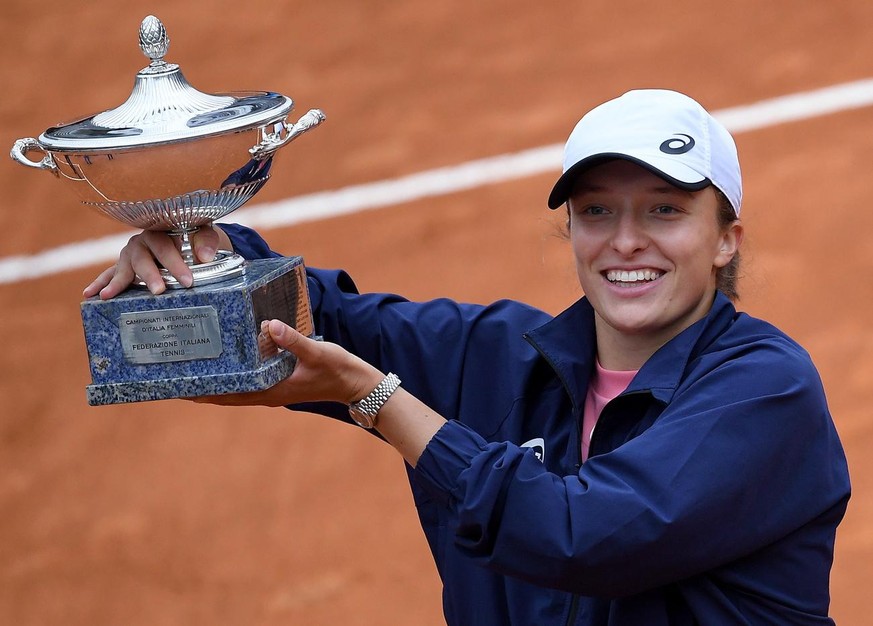 epa09204315 Iga Swiatek of Poland celebrates with the trophy after defeating Karolina Pliskova of Czech Republic in their women&#039;s singles final match at the Italian Open tennis tournament in Rome ...