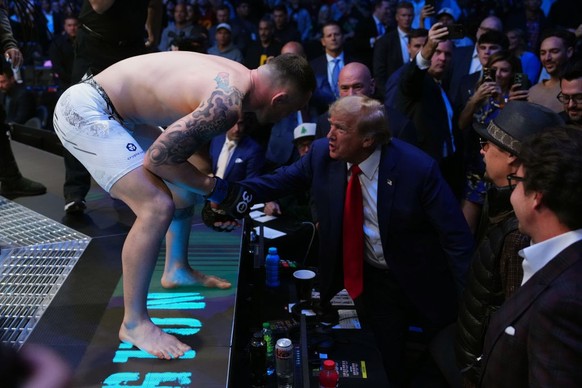 LAS VEGAS, NEVADA - DECEMBER 16: (L-R) Colby Covington talks to former United States president Donald Trump at the beginning of the UFC welterweight championship fight during the UFC 296 event at T-Mo ...