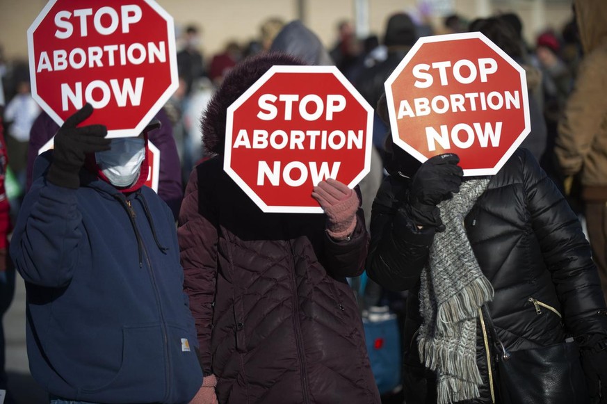 Anti-abortion advocates use their signs to block the sun during a rally near the north steps of the Nebraska State Capitol on Saturday, Jan. 16, 2021 in Lincoln, Neb. (Kenneth Ferriera/Lincoln Journal ...