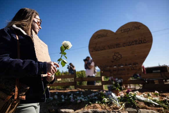 (FILES) A woman arrives to lay a flower before a wooden heart after a march in and around Mazan&#039;s village, southeastern France, to support Gisele Pelicot and to protest against violence towards w ...
