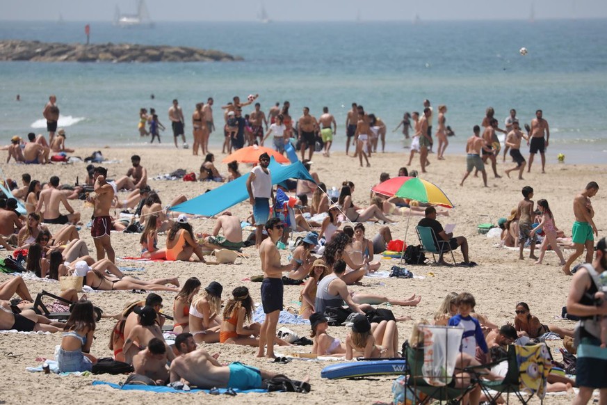 epa09140963 People without face masks enjoy the weather on the beach of Tel Aviv, 17 April 2021. Israel ends obligatory use of face masks outdoors starting from 18 April following a successful vaccina ...