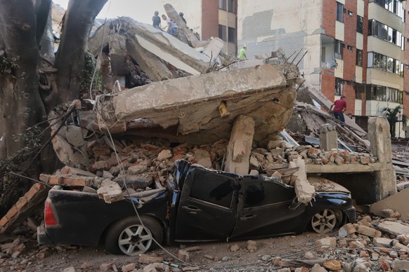 A vehicle is crushed by debris after an earthquake struck Cali, Colombia, Monday, Aug. 10, 2026. (AP Photo/Juan Diaz)