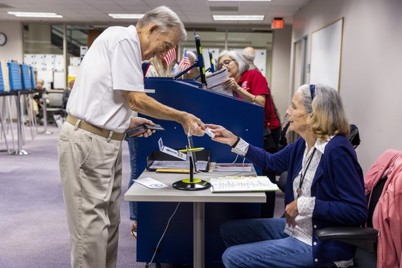 epa11615872 Fairfax County voters check in before voting in the 2024 Presidential election at the Fairfax County Government Center polling place in Fairfax, Virginia, USA, 20 September 2024. Early in- ...