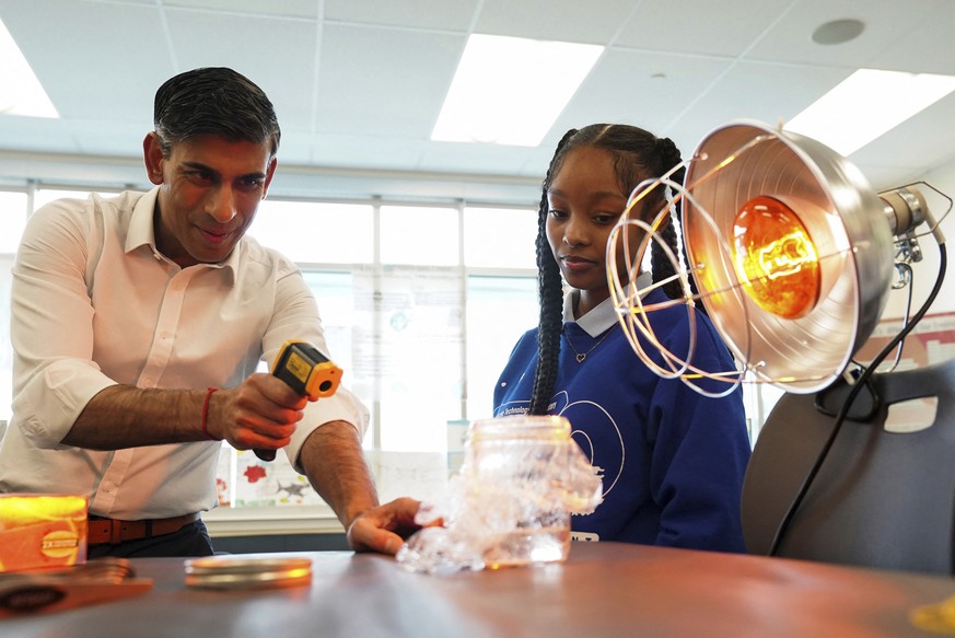 A Washington, Rishi Sunak participe à une expérience scientifique lors de sa visite dans une école, mercredi.