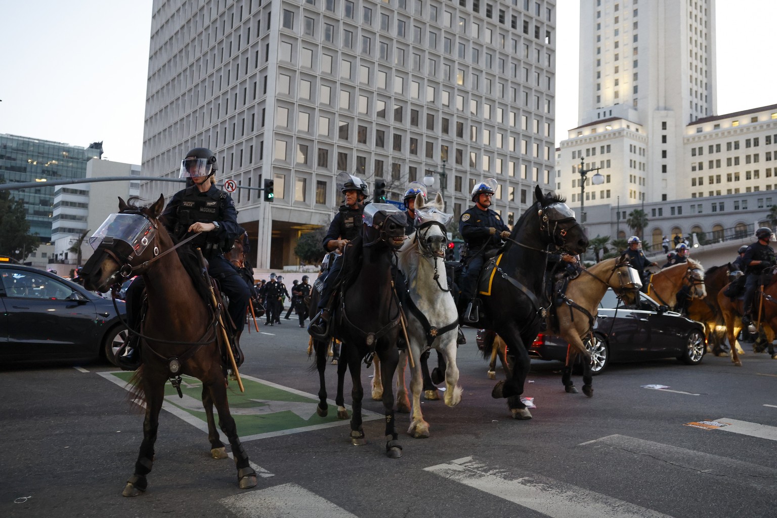 epa12169446 Los Angeles Police Department officers ride on horses as a curfew goes into effect in areas of Downtown Los Angeles, California, USA, 10 June 2025. US President Donald Trump has deployed 2 ...
