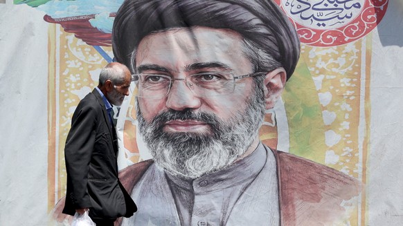epa13046115 An Iranian man walks past a poster of Iranian supreme leader Ayatollah Mojtaba Khamenei in a street in Tehran, Iran, 18 June 2026. Iran and the US signed a peace agreement to end the war b ...