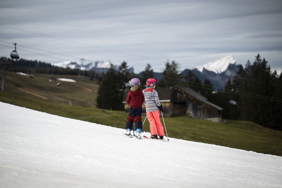 Skifahrer vergnuegen sich auf einer Kunstschneepiste in gruener Landschaft, aufgenommen am Mittwoch, 4. Januar 2023, in Wildhaus im Obertoggenburg. (KEYSTONE/Gian Ehrenzeller) People enjoy themselves  ...