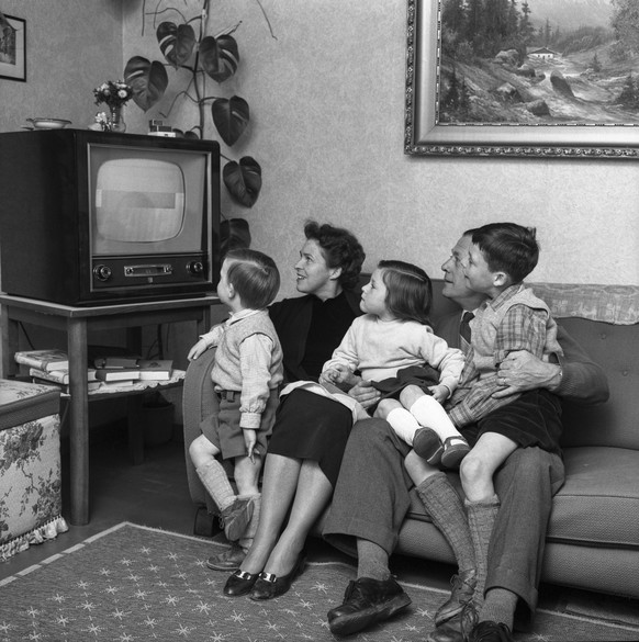 Die Familie Schuetz aus Spiegel bei Bern sitzt am 20. Maerz 1957 in ihrem Wohnzimmer vor dem Fernsehapparat und schaut fern. (KEYSTONE/PHOTOPRESS-ARCHIV/KRAFT)