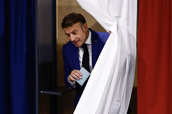 epa11447115 French President Emmanuel Macron leaves a voting booth at a polling station during the first round of the early French parliamentary elections, in Le Touquet-Paris-Plage, northern France,  ...