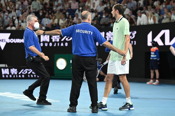 epa09717794 Daniil Medvedev of Russia is surrounded by security after a protester jumped onto the court during the men&#039;s singles final against Rafael Nadal of Spain at the Australian Open grand s ...