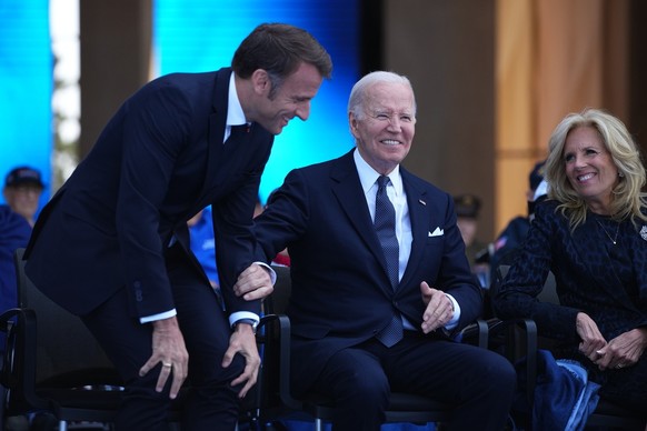 epa11393158 President Joe Biden and French President Emmanuel Macron react with First Lady Jill Biden during a commemorative ceremony to mark D-Day 80th anniversary, Thursday, June 6, 2024 at the US c ...