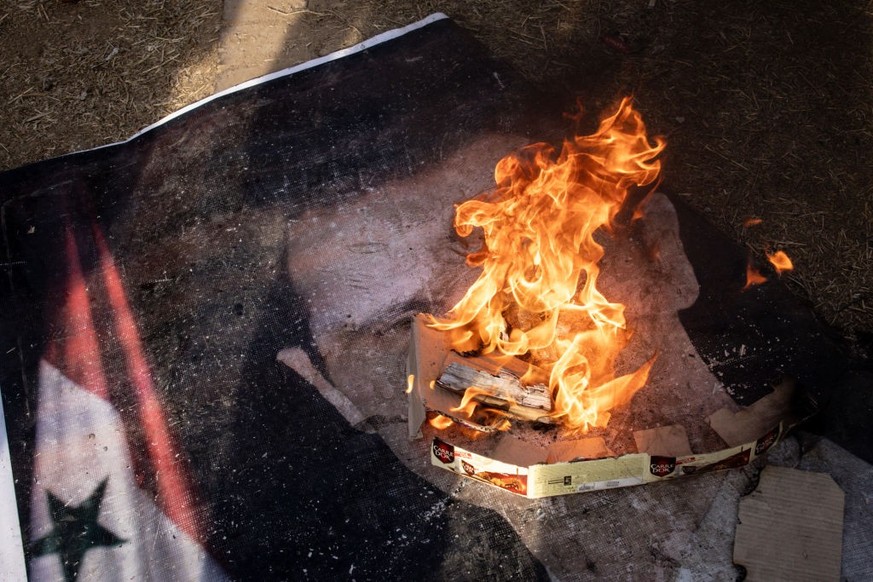 DAMASCUS, SYRIA - DECEMBER 20: Men burn a poster showing the face of Bashar al-Assad in Umayyad Square on December 20, 2024 in Damascus, Syria. On December 8, rebel forces in Syria retook the capital  ...