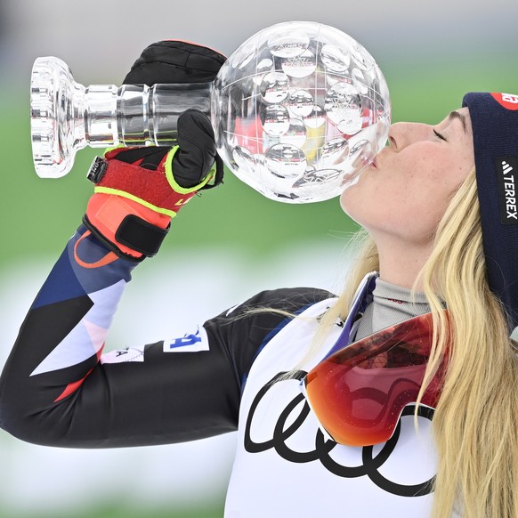 Mikaela Shiffrin of the United States celebrates with the women&#039;s slalom overall leader crystal globe trophy in the finish area during the women&#039;s slalom race at the FIS Alpine Skiing World  ...