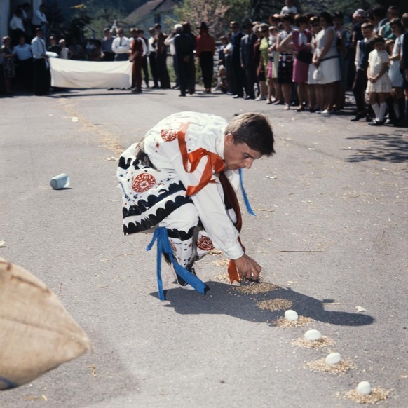 Le coureur, appelé &quot;Eierbub&quot;, doit enlever les œufs les uns après les autres le long de la piste des œufs pendant la course traditionnelle et les jeter dans un panier de récupération avec de ...