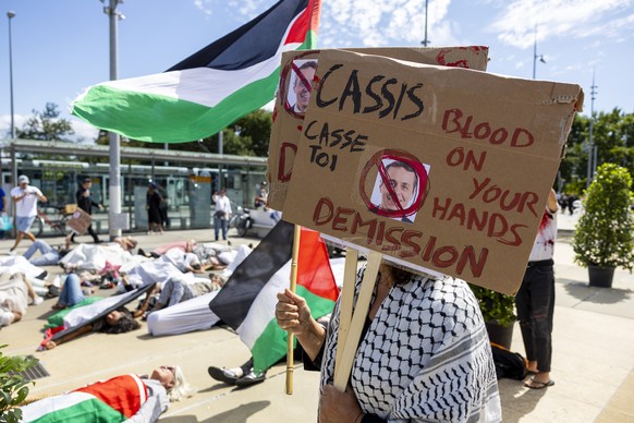 Pro-Palestinian demonstrators protest during the speech of Swiss Foreign Minister Ignazio Cassis at a symbolic action to mark the 75th anniversary of the Geneva Conventions on Place des Nations In fro ...