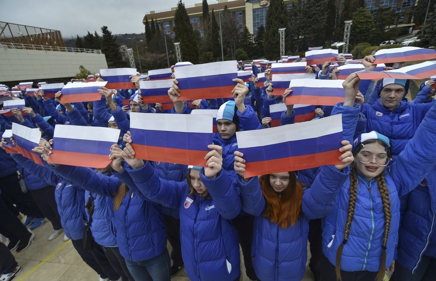 epa10524586 Youths hold Russian national flags during the &#039;Crimean spring - nine years together&#039; rally-concert at the International Child Centre &#039;Artek&#039; in Gurzuf, Crimea, 15 March ...