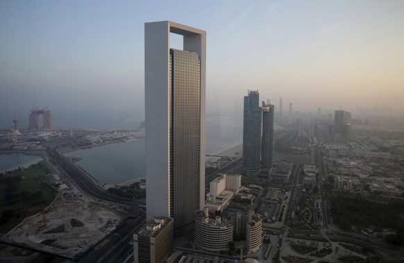 FILE - The sun rises over the headquarters of the Abu Dhabi National Oil Co. headquarters that dominates the skyline in Abu Dhabi, United Arab Emirates, on Nov. 7, 2016. The state-run oil giant in the ...