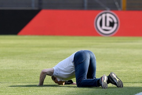 Servette&#039;s Trainer Alain Geiger kisses the grass during the Super League soccer match FC Lugano against FC Servette, at the Cornaredo stadium in Lugano, Sunday, April 25, 2021. (KEYSTONE/Ti-Press ...