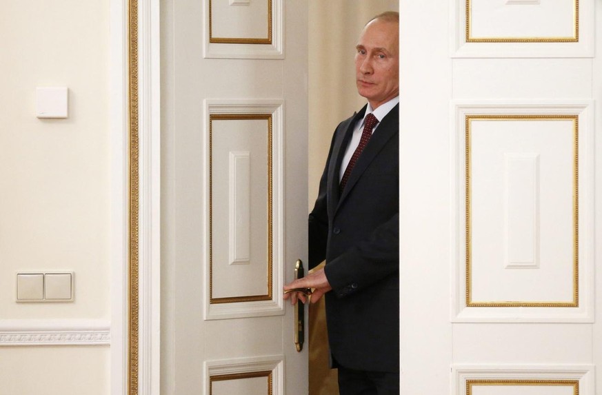 epa04171143 Russian President Vladimir Putin enters the room before his meeting with Chief executive officer of Royal Dutch Shell Ben van Beurden (not pictured) at the Novo-Ogaryovo state residence ou ...