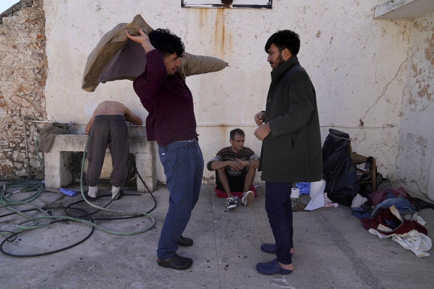 Migrants, most of them from Afghanistan, gather at an old school used as a temporary shelter on the island of Kythira, southern Greece, Thursday, Oct. 6, 2022. Bodies floated amid splintered wreckage ...