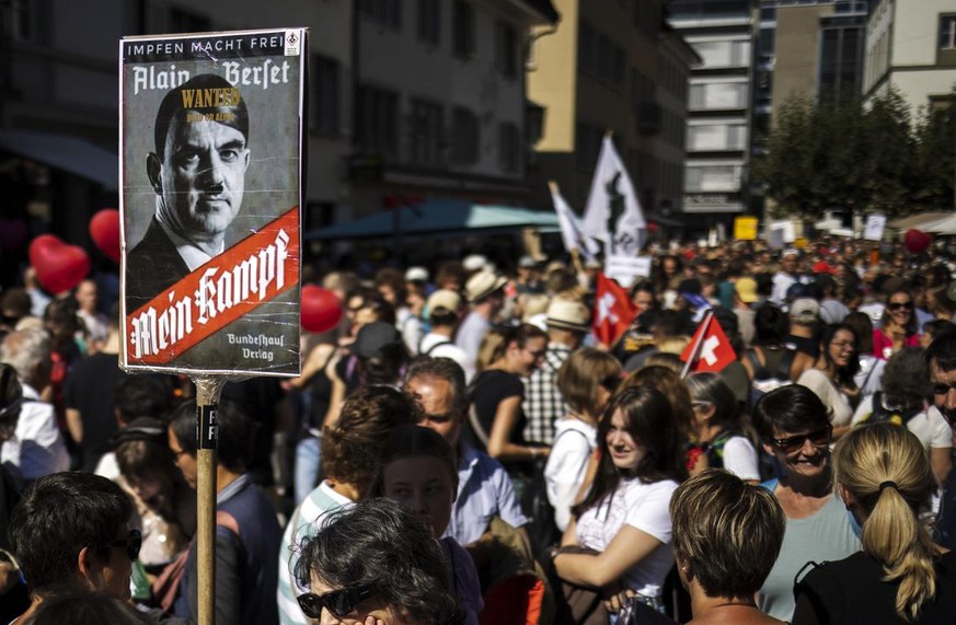 Eine Demonstrantin haelt ein Plakat mit einem verfremdeten Bild von Bundesrat Alain Berset und dem Schriftzug &quot;Mein Kampf&quot;, bei einer Kundgebung gegen die Massnahmen zur Eindaemmung des Coro ...