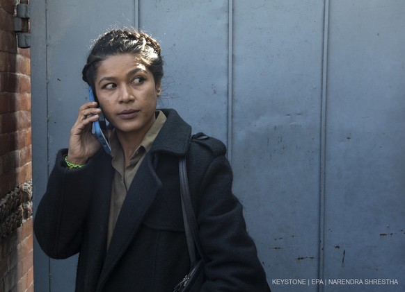 epa10376976 Nihita Biswas, the Nepalese wife of Charles Sobraj, uses her mobile phone after her husband was brought to the Immigration office prior to his release from custody, in Kathmandu, Nepal, 23 ...