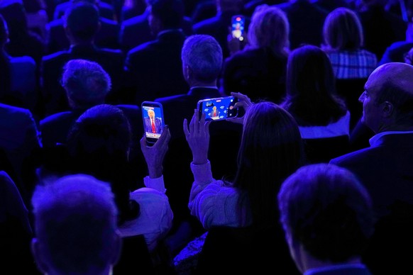 People film President Donald Trump during his speech at the World Economic Forum in Davos, Switzerland, Wednesday, Jan. 21, 2026. (AP Photo/Markus Schreiber)