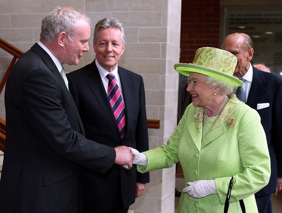 BELFAST, NORTHERN IRELAND - JUNE 27: Queen Elizabeth II shakes hands with Deputy First Minister of Northern Ireland Martin McGuinness watched by First Minister Peter Robinson (C) at the Lyric Theatre  ...