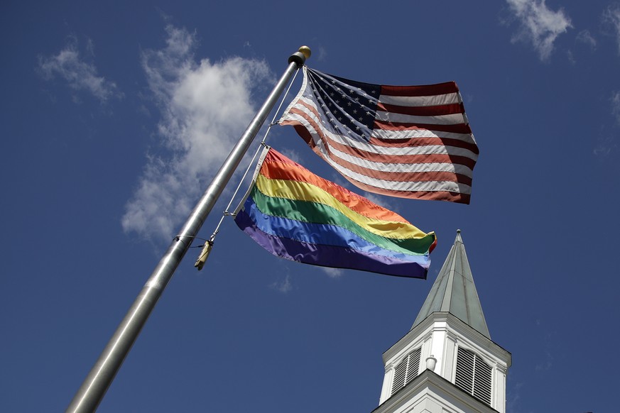 Un drapeau arc-en-ciel de la gay pride flotte avec le drapeau des Etats-Unis.