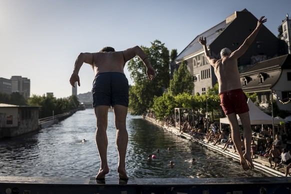 Zwei Maenner springen am Flussbad Oberer Letten in die Limmat waehrend eines Hitzetags am Donnerstag, 18. Juni 2026 in Zuerich. Seit Donnerstag gibt der Bund Hitzewarnungen der Stufen 3 und 4 heraus.  ...