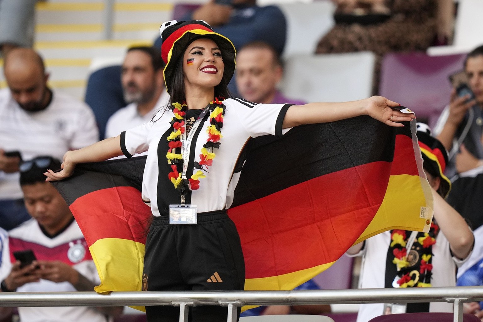 A woman wearing the German colors cheers on the tribune prior to the World Cup group E soccer match between Germany and Japan, at the Khalifa International Stadium in Doha, Qatar, Wednesday, Nov. 23,  ...