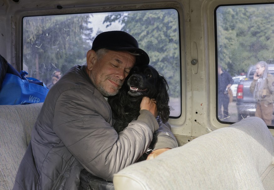 epa11335899 Local man Oleksandr, 64, with his dog 'Gerda' sits in a bus as they are evacuated from territories bordering Russia, on the outskirts of Vovchansk, Kharkiv region, northeastern U ...