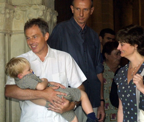 VENERQUE, FRANCE - AUGUST 18: British Prime Minister Tony Blair, holding his son Leo, departs Saint-Pierre de Venerque church after mass August 18, 2002 in Venerque, southwestern France. Tony and his  ...