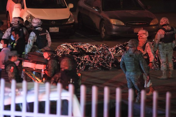 epa10546600 Covered bodies of some of the 37 migrants that have died during a fire at the Immigration National Institute of Ciudad Juarez, in the state of Chihuahua, Mexico on 28 March 2023. EPA/Luis  ...