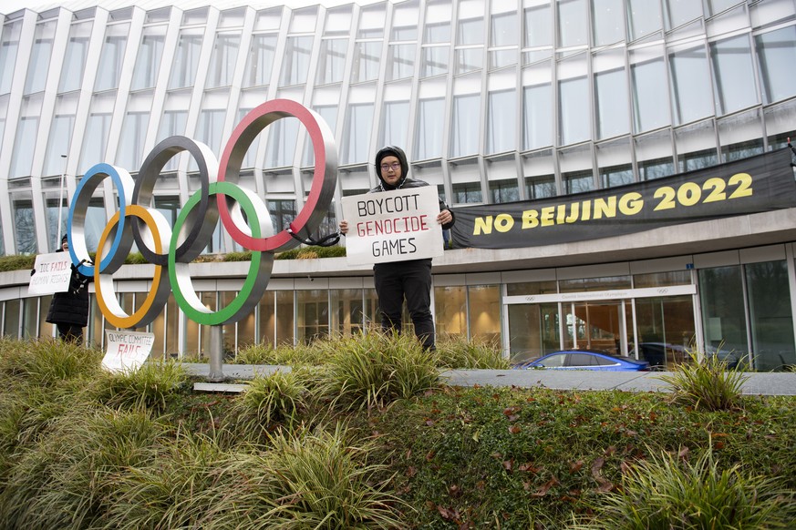 Des manifestants tiennent des pancartes contre les Jeux olympiques d'hiver de Pékin 2022, devant le siège du Comité international olympique (CIO) à Lausanne.