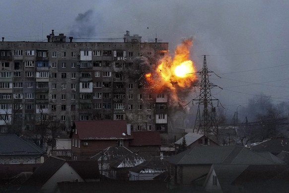 An explosion is seen in an apartment building after Russian&#039;s army tank fires in Mariupol, Ukraine, Friday, March 11, 2022. (AP Photo/Evgeniy Maloletka)