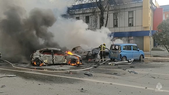 FILE - In this photo taken from video released by Russia Emergency Situations Ministry telegram channel on Saturday, Dec. 30, 2023, firefighters extinguish burning cars after shelling in Belgorod, Rus ...