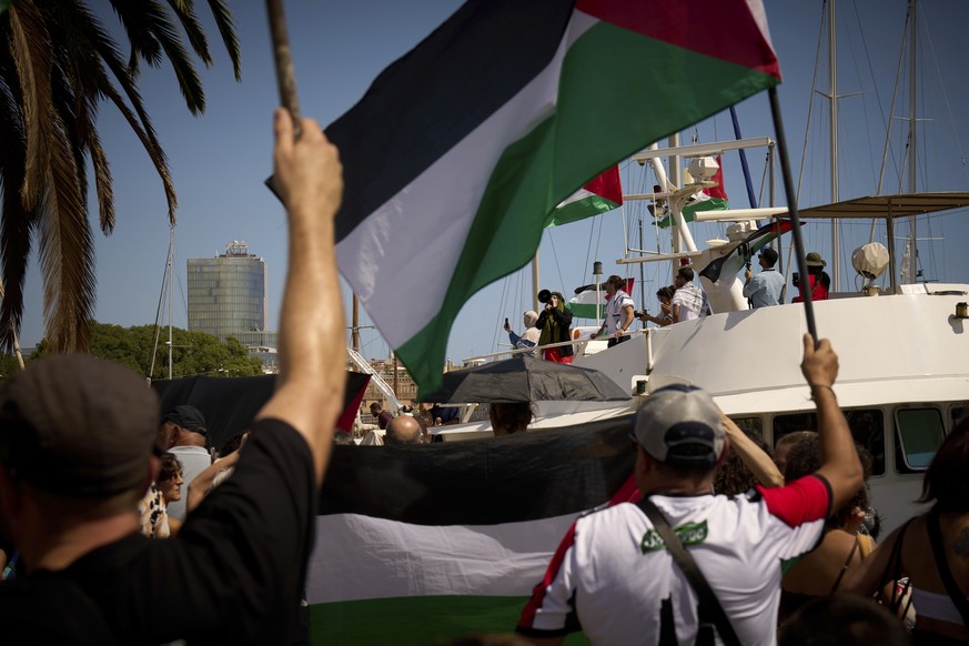 Demonstrators shout slogans on a boat ahead of the launch of a civilian flotilla bound for Gaza, aiming to break the Israeli blockade and deliver humanitarian aid in Barcelona, Spain, Sunday, Aug. 31, ...