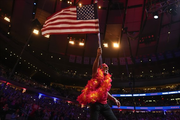 FILE - Hulk Hogan waves an U.S. flag before Republican presidential nominee, former President Donald Trump, speaks at a campaign rally at Madison Square Garden, Oct. 27, 2024, in New York. (AP Photo/A ...