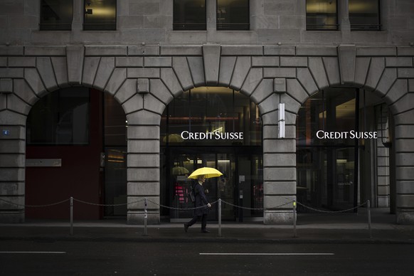 A person walks past a logo of the Swiss bank Credit Suisse in Zurich, Switzerland, Friday, March 24, 2023. (Michael Buholzer/Keystone via AP)