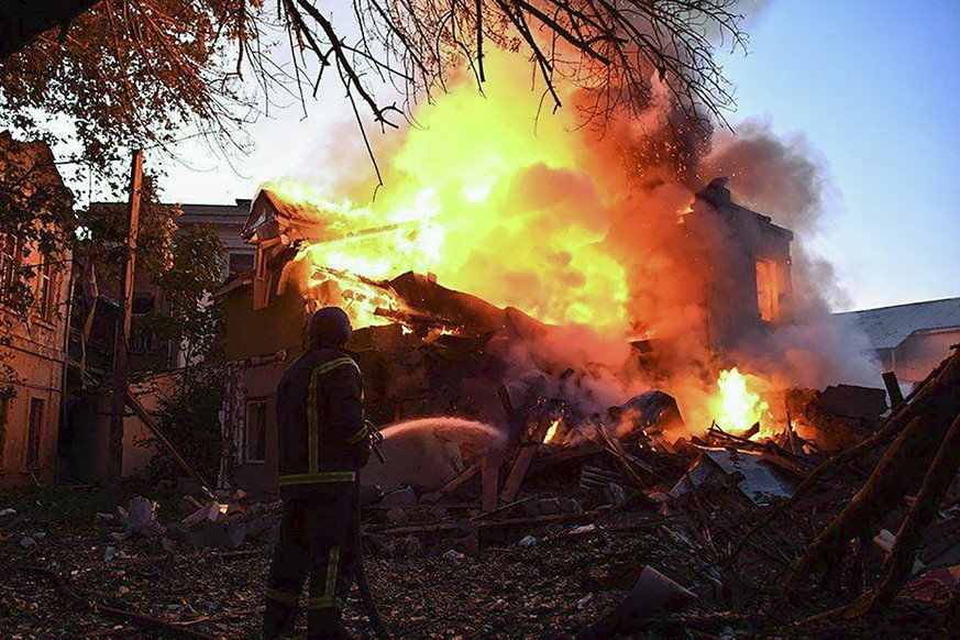 epa10066460 A handout photo released by the press service of the State Emergency Service of Ukraine shows a firefighter putting out a fire at a residential building after shelling hit the village of S ...