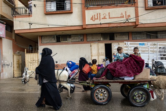 epaselect epa11321275 Internally displaced Palestinians, including women and children, carry their belongings on a donkey-drawn cart after an evacuation order issued by the Israeli army, in Rafah, sou ...