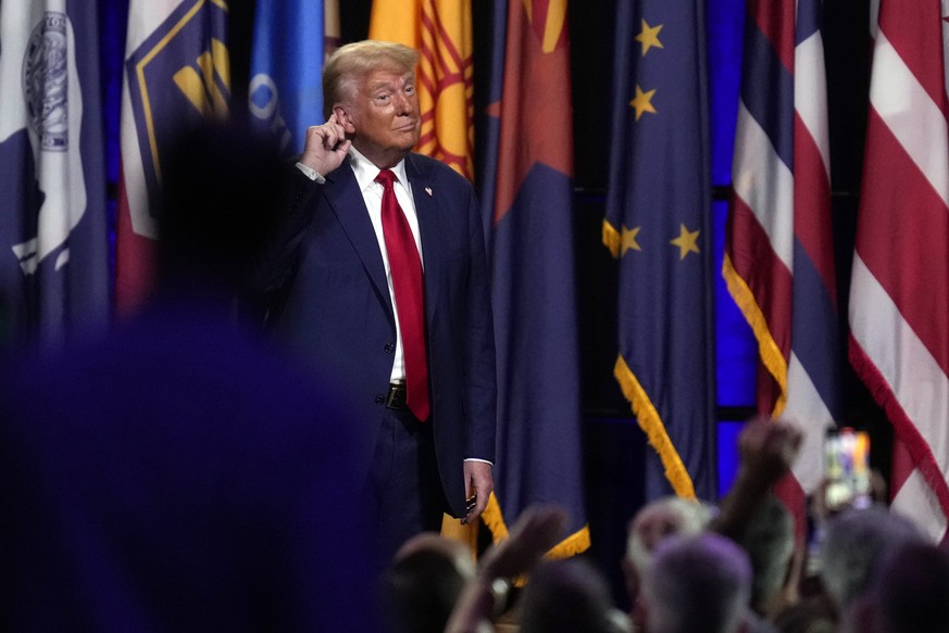 Republican presidential nominee former President Donald Trump puts his hand to his ear after speaking at the National Guard Association of the United States&#039; 146th General Conference, Monday, Aug ...