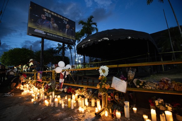 epa12026338 People light candles during a vigil for the victims of a recent accident at a nightclub, in Santo Domingo, Dominican Republic, 11 April 2025. Dozens of people lit candles, carried balloons ...
