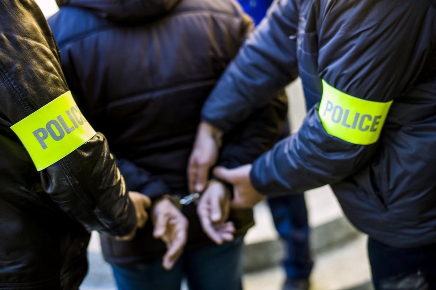 Policemen in plainclothes of the cantonal police of Valais apply cuffs to an individual before the court of Sion, Switzerland, on April 9, 2015. (KEYSTONE/Olivier Maire)

Des policiers en civil de la  ...